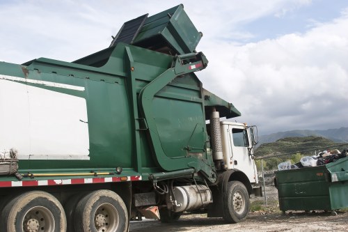 Waste management professionals handling a skip in Teddington